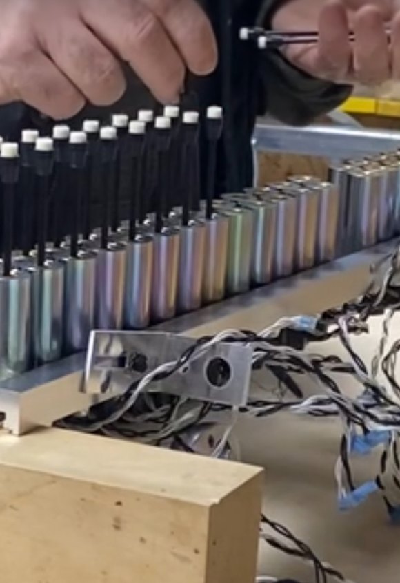 Self-playing piano solenoid rail being fitted by hand